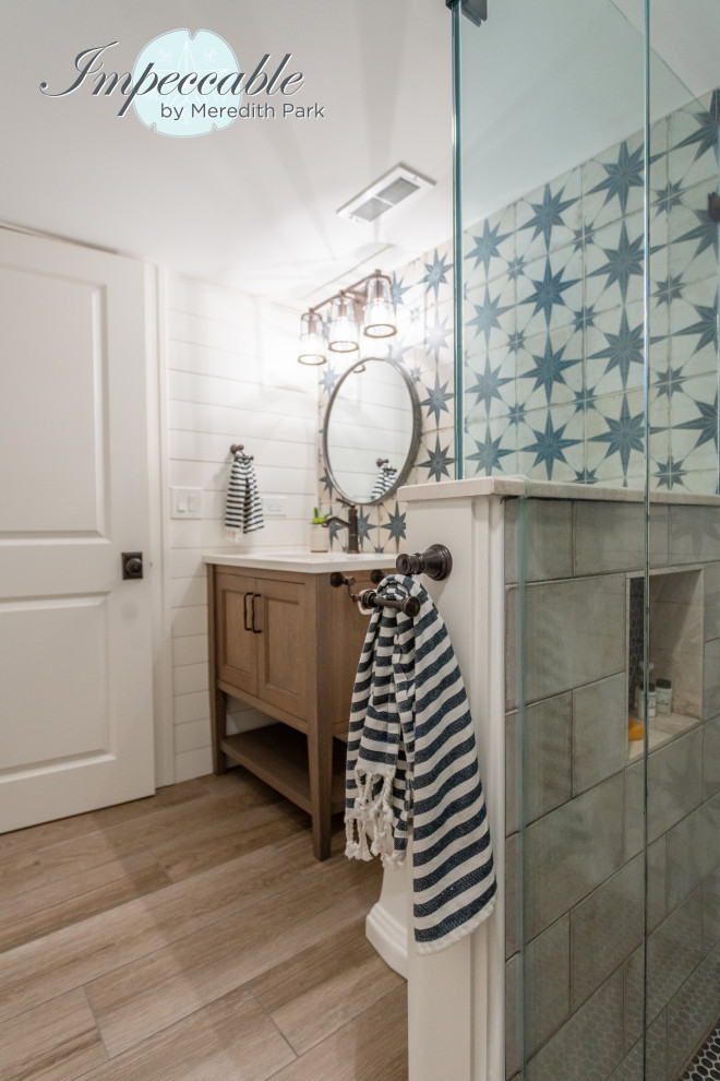 Пример оригинального дизайна: маленькая ванная комната в стиле неоклассика (современная классика) с плоскими фасадами, коричневыми фасадами, открытым душем, раздельным унитазом, синей плиткой, керамогранитной плиткой, белыми стенами, полом из плитки под дерево, душевой кабиной, врезной раковиной, столешницей из искусственного кварца, коричневым полом, душем с распашными дверями, белой столешницей, тумбой под одну раковину, напольной тумбой и стенами из вагонки для на участке и в саду