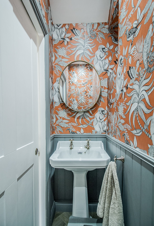 Inspiration för ett litet funkis badrum för barn, med vita skåp, en toalettstol med hel cisternkåpa, orange väggar, marmorgolv, ett piedestal handfat, grått golv och med dusch som är öppen