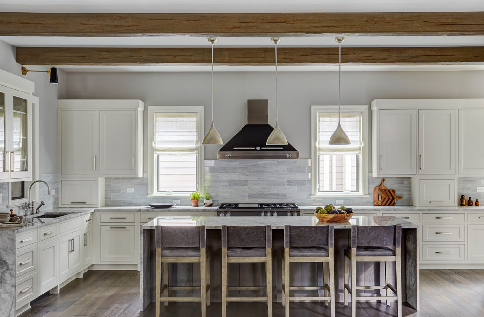 Large transitional l-shaped brown floor and dark wood floor kitchen photo in Chicago with an undermount sink, shaker cabinets, white cabinets, stainless steel appliances, an island, gray backsplash, gray countertops, marble countertops and marble backsplash