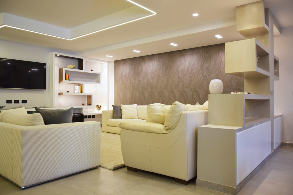 Photo of a modern open concept family room in Rome with a library, white walls, porcelain floors, a wall-mounted tv and beige floor.