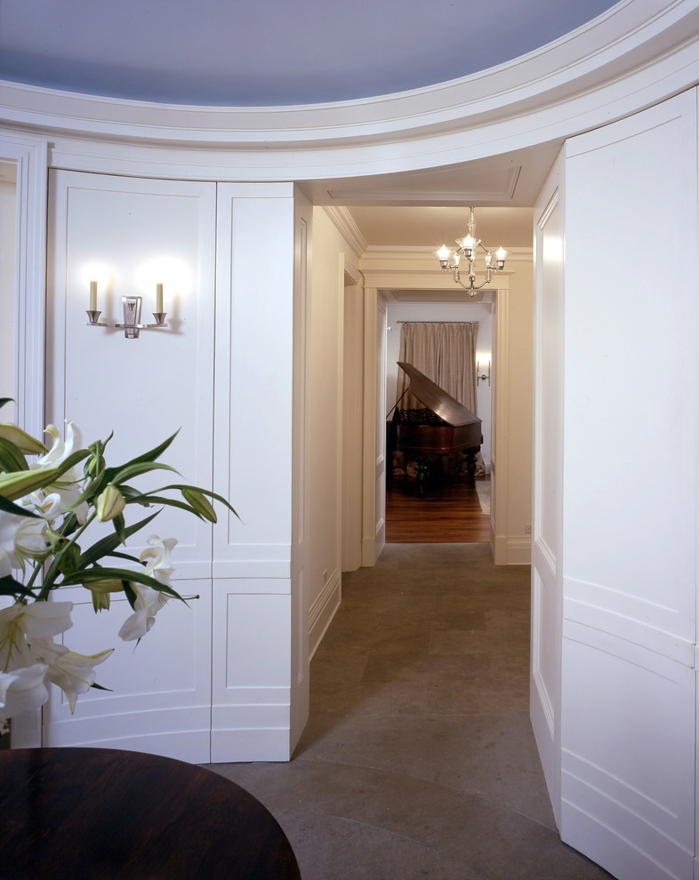 Photo of a large transitional hallway in New York with limestone floors.