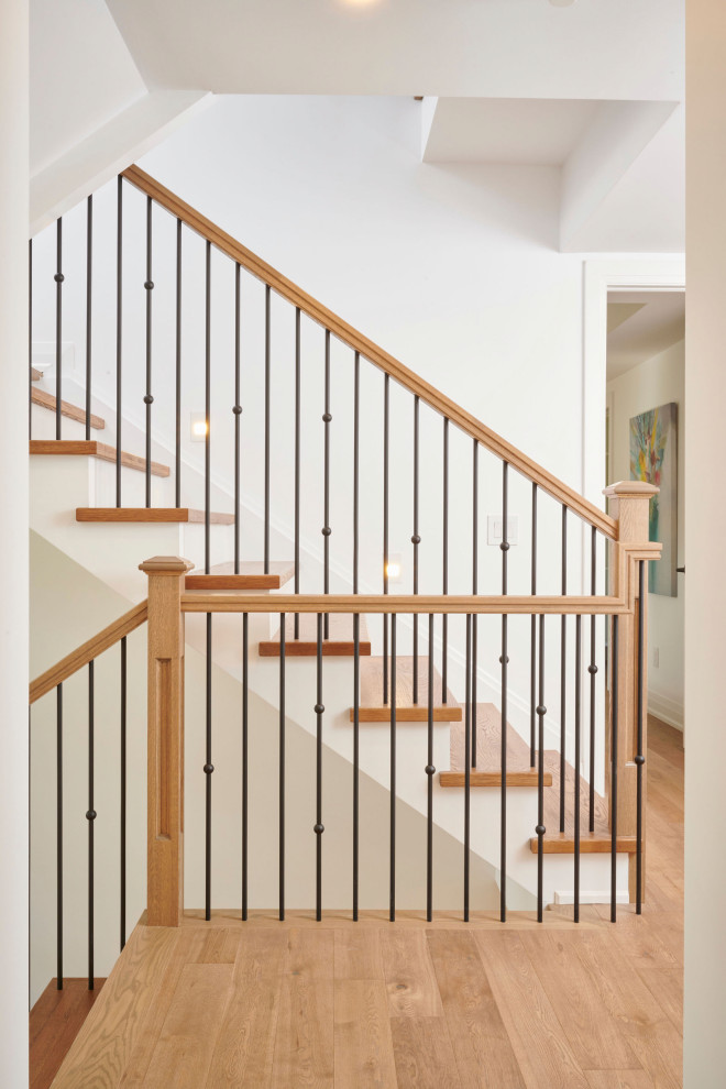 Стильный дизайн: угловая лестница в современном стиле с деревянными ступенями, крашенными деревянными подступенками и металлическими перилами - последний тренд