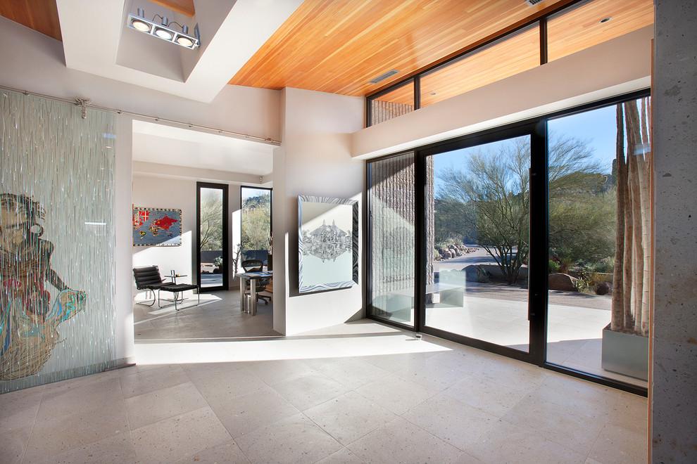Example of a huge trendy entryway design in Phoenix with white walls and a glass front door