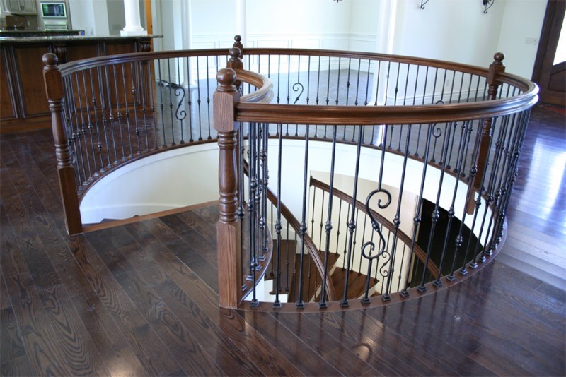 Mid-sized traditional wood curved staircase in St Louis with wood risers and wood railing.