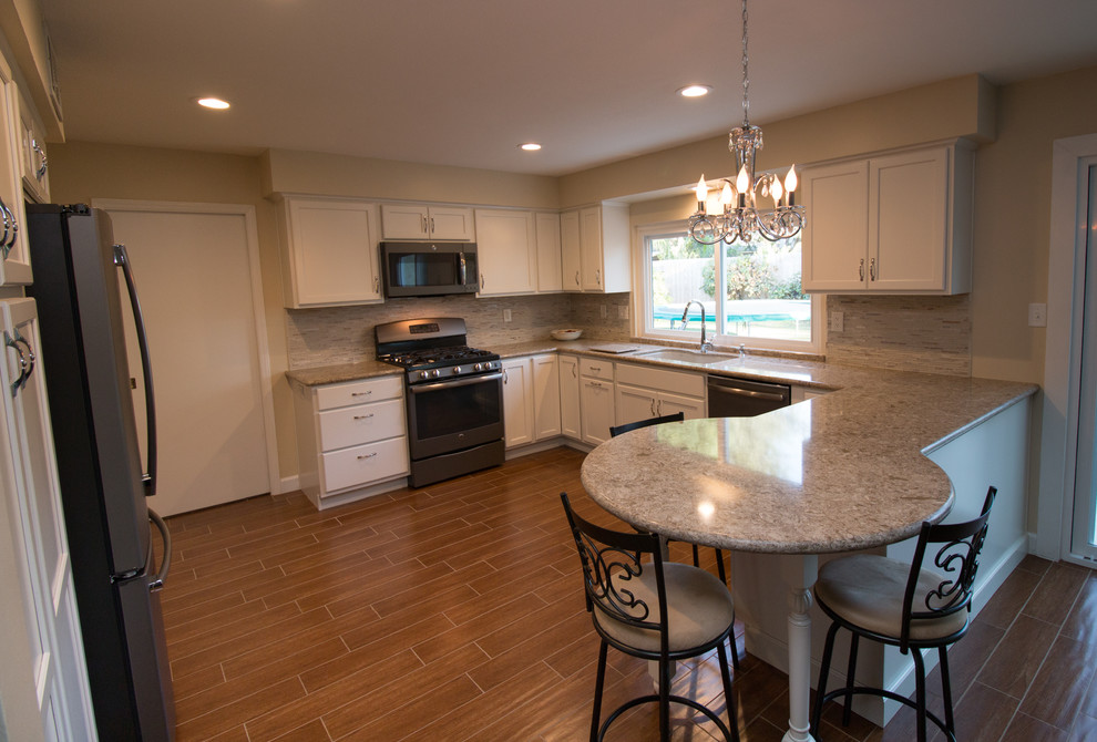 Example of a mid-sized transitional u-shaped porcelain tile open concept kitchen design with an undermount sink, recessed-panel cabinets, beige cabinets, quartz countertops, beige backsplash, mosaic tile backsplash and colored appliances
