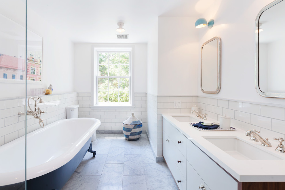 Photo of a transitional master bathroom in New York with flat-panel cabinets, white cabinets, a claw-foot tub, white tile, subway tile, white walls and an undermount sink.