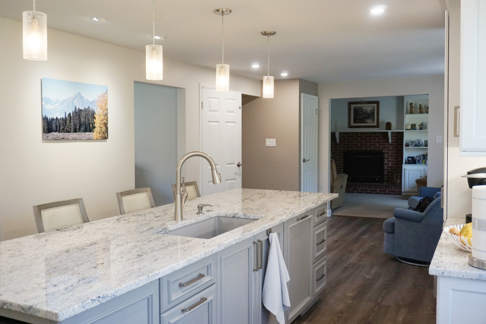 Photo of a mid-sized transitional kitchen in Other with an undermount sink, recessed-panel cabinets, white cabinets, granite benchtops, grey splashback, stainless steel appliances and white benchtop.