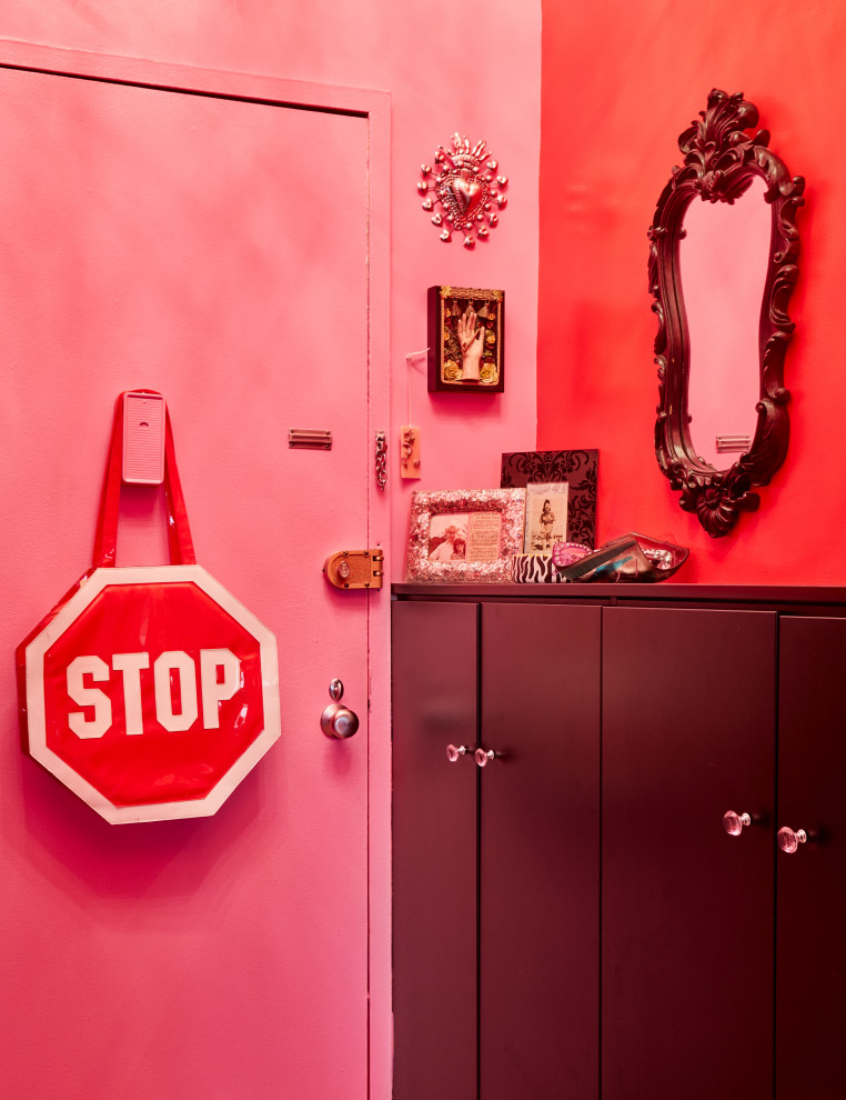 Cette photo montre une petite entrée éclectique avec un couloir, un mur rose, parquet clair, une porte simple, une porte violette et un sol beige.