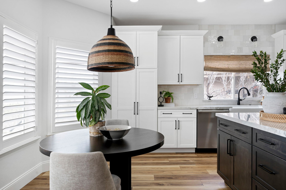 Transitional vinyl floor and brown floor kitchen photo with a farmhouse sink, shaker cabinets, white cabinets, quartzite countertops, white backsplash and stainless steel appliances