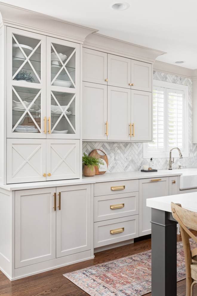 Large transitional u-shaped dark wood floor and brown floor eat-in kitchen photo with a farmhouse sink, shaker cabinets, white cabinets, quartzite countertops, gray backsplash, marble backsplash, stainless steel appliances, an island and white countertops