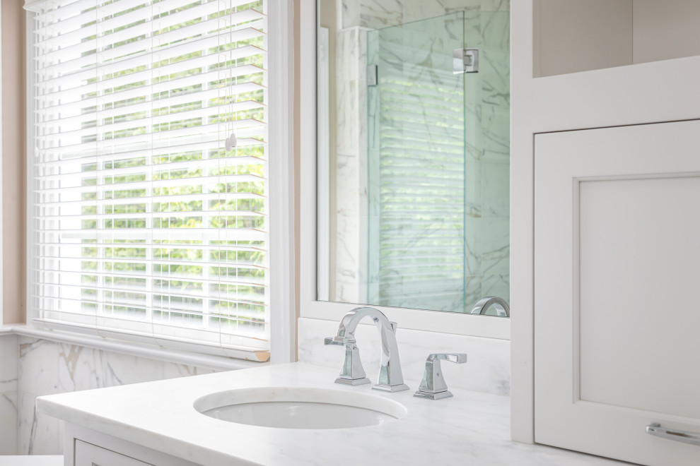 Inspiration for a mid-sized transitional master white tile and marble tile dark wood floor and brown floor freestanding bathtub remodel in Raleigh with recessed-panel cabinets, white cabinets, beige walls, an undermount sink, marble countertops, a hinged shower door and white countertops