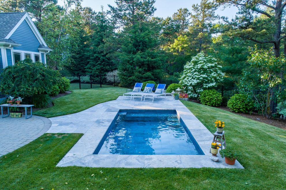 Ejemplo de piscina pequeña rectangular en patio trasero con paisajismo de piscina