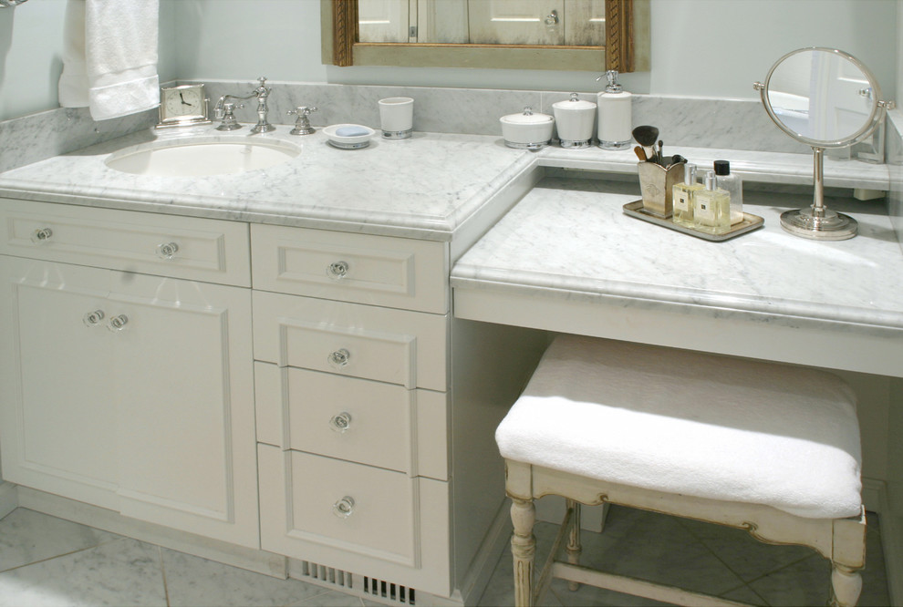 This is an example of a mid-sized arts and crafts master bathroom in Seattle with an undermount sink, raised-panel cabinets, white cabinets, marble benchtops, a freestanding tub, a corner shower, white tile, stone tile and blue walls.