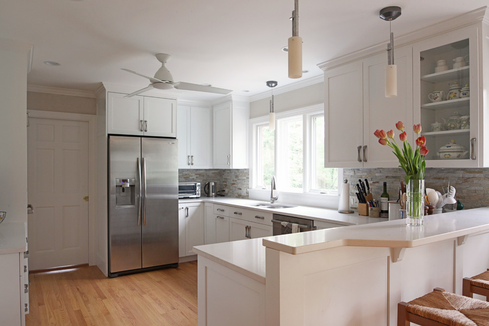 Example of a mid-sized transitional u-shaped eat-in kitchen design with flat-panel cabinets, white cabinets and a peninsula