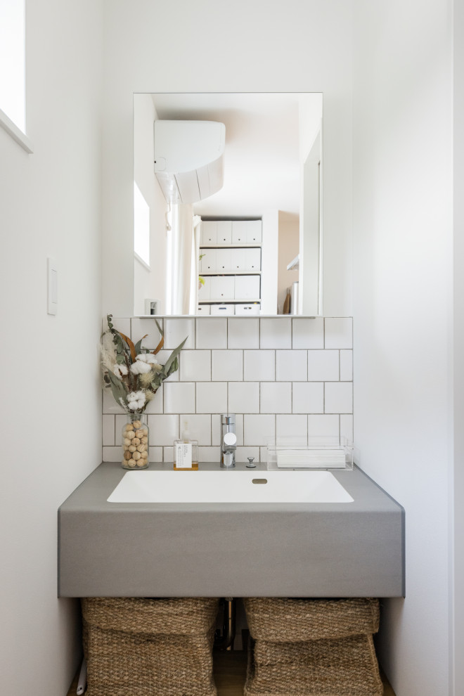 Design ideas for a scandinavian cloakroom in Other with open cabinets, white cabinets, white tiles, ceramic tiles, white walls, medium hardwood flooring, an integrated sink, brown floors, grey worktops and wallpapered walls.