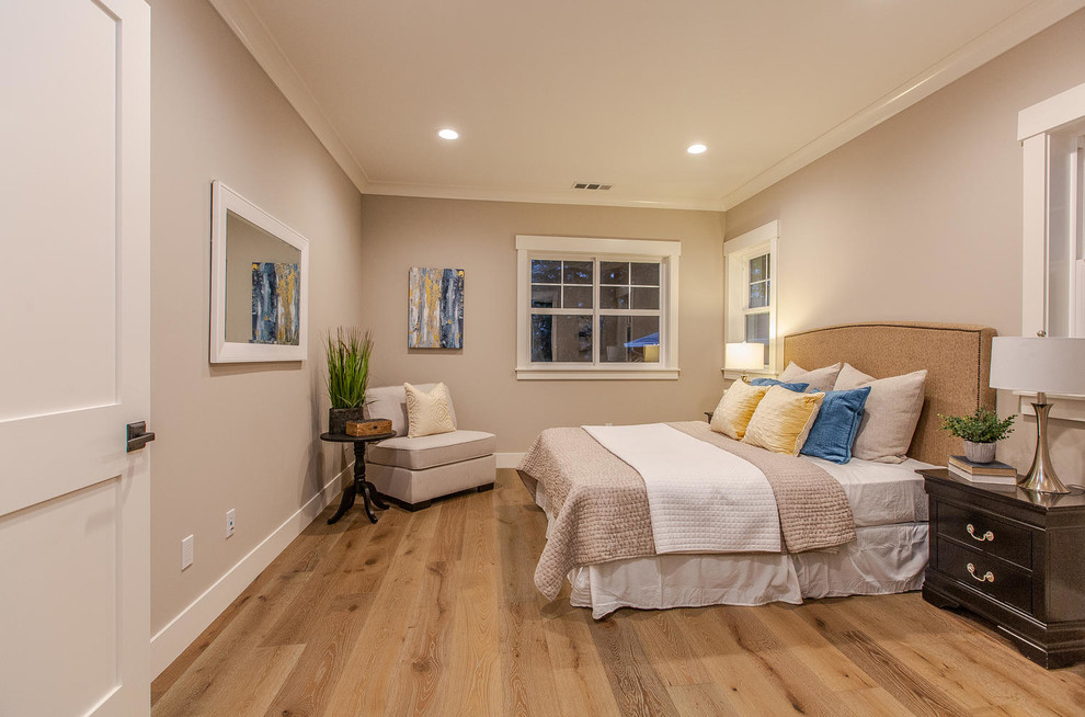 Mid-sized country guest bedroom in San Francisco with beige walls, light hardwood floors, no fireplace and beige floor.