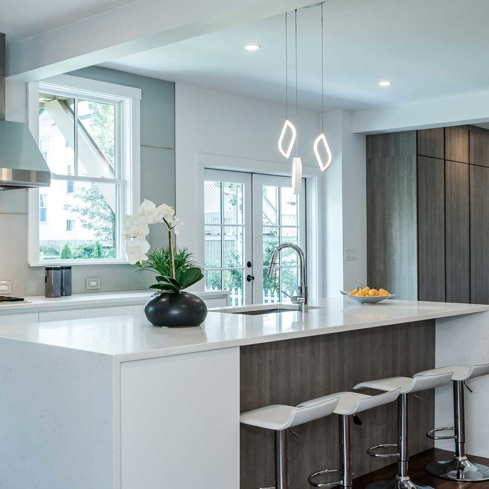 Photo of a mid-sized contemporary single-wall open plan kitchen in Boston with flat-panel cabinets, medium wood cabinets, quartz benchtops, stainless steel appliances, dark hardwood floors, with island and brown floor.