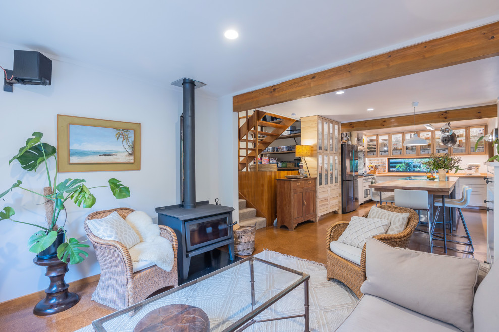Idee per un piccolo soggiorno boho chic aperto con pareti bianche, pavimento in sughero, stufa a legna e pavimento marrone