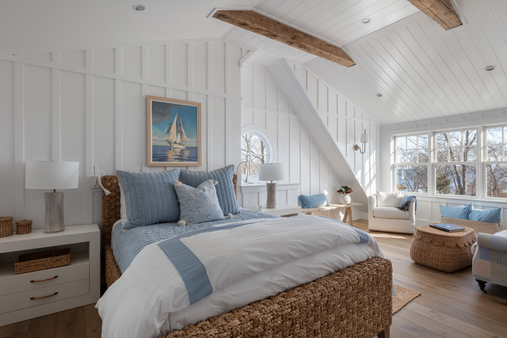 На фото: хозяйская спальня в морском стиле с белыми стенами, паркетным полом среднего тона, коричневым полом, балками на потолке, потолком из вагонки и панелями на части стены