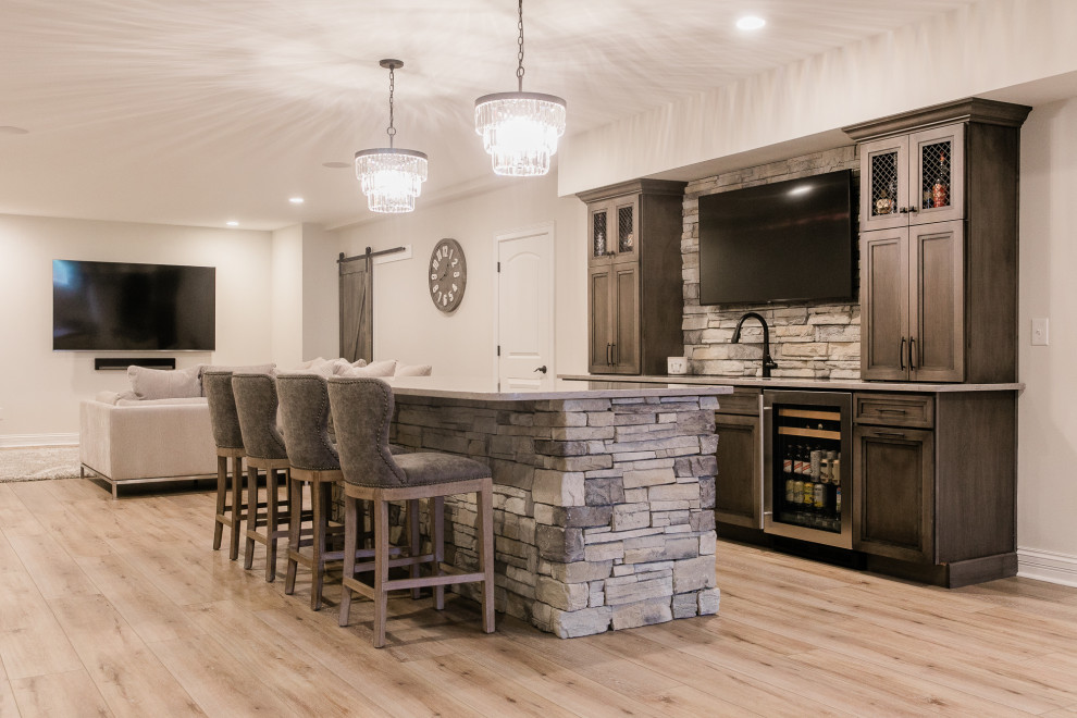This is an example of a large country look-out basement in Other with beige walls, vinyl floors, a corner fireplace, a stone fireplace surround and beige floor.