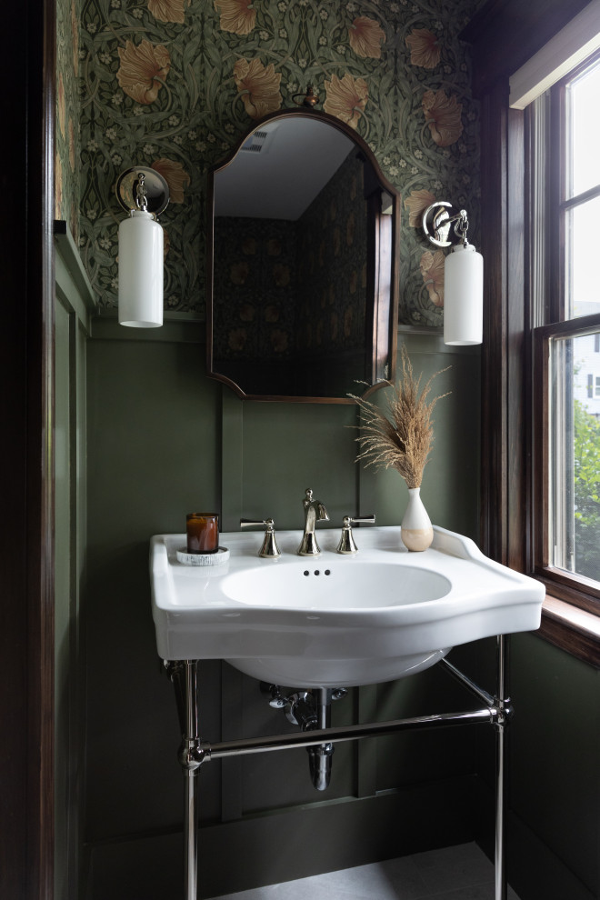 Cette photo montre un WC et toilettes craftsman avec un mur vert, un sol en carrelage de porcelaine, un sol gris, meuble-lavabo sur pied, boiseries, du papier peint et un plan vasque.