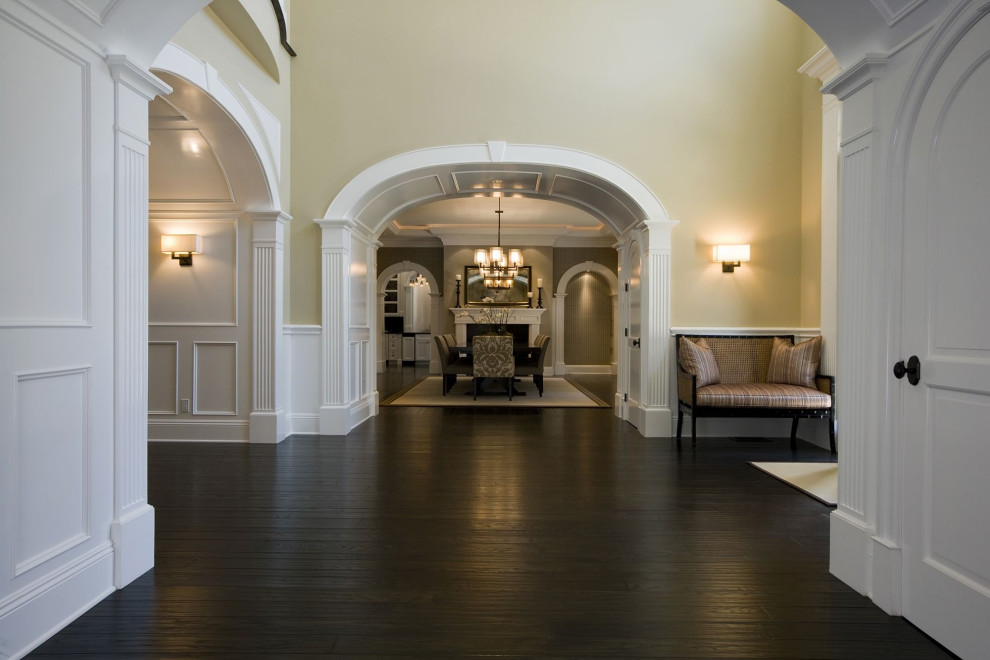 Design ideas for a large traditional foyer in Sacramento with yellow walls, dark hardwood floors, a single front door, brown floor and a white front door.