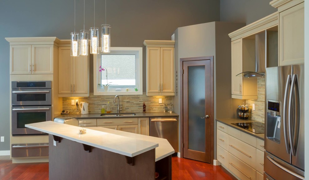 Inspiration for a transitional l-shaped medium tone wood floor kitchen remodel in Miami with a double-bowl sink, recessed-panel cabinets, white cabinets, quartzite countertops, beige backsplash, matchstick tile backsplash, stainless steel appliances and an island