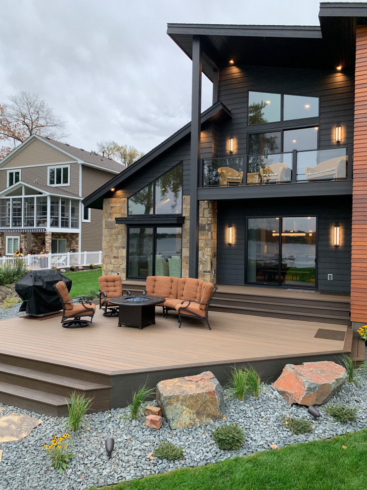 Photo of a large and black contemporary two floor detached house in Minneapolis with mixed cladding, a lean-to roof, a shingle roof, a black roof and shiplap cladding.
