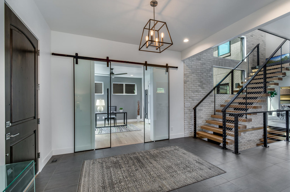 Design ideas for a large contemporary foyer in Denver with white walls, porcelain floors, a single front door, a dark wood front door and grey floor.