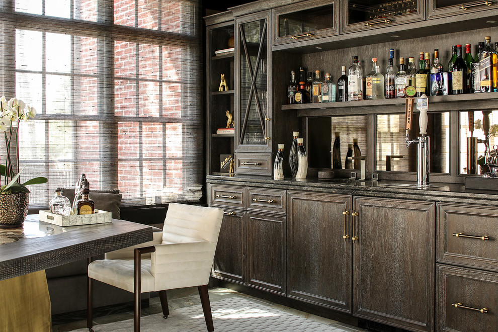 Photo of a mid-sized traditional single-wall wet bar in New York with dark wood cabinets, marble benchtops, mirror splashback, carpet and grey floor.