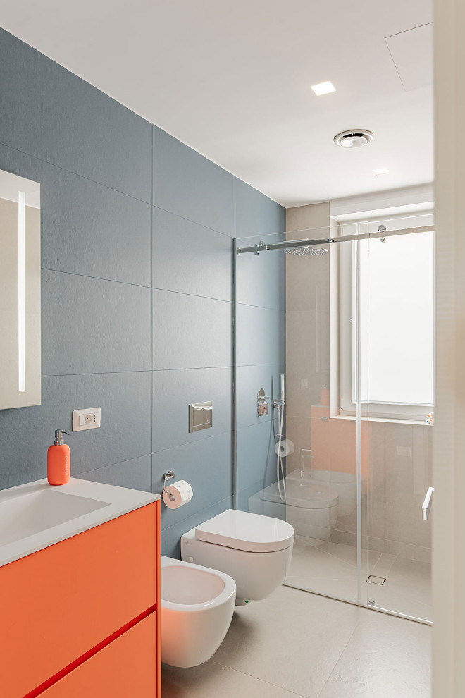 Idéer för att renovera ett funkis vit vitt toalett, med släta luckor, orange skåp, en vägghängd toalettstol, blå kakel, porslinskakel, blå väggar, klinkergolv i porslin, ett avlångt handfat, bänkskiva i kvartsit och beiget golv