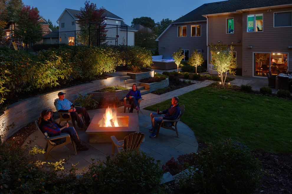 Contemporary backyard garden in Minneapolis with a fire feature and natural stone pavers.