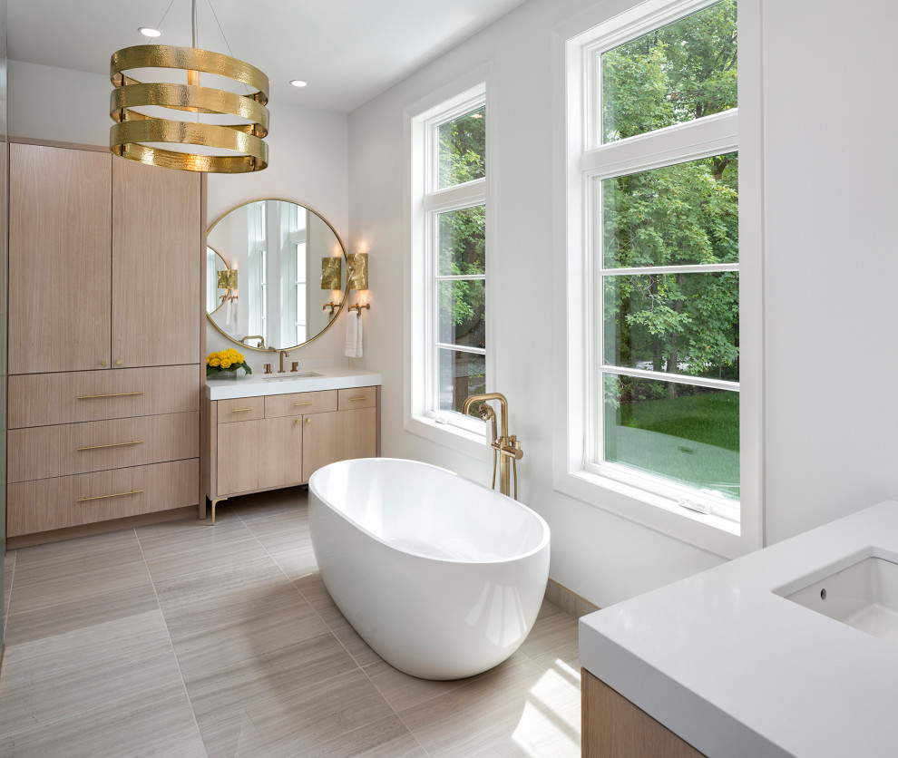 Inredning av ett modernt vit vitt en-suite badrum, med släta luckor, skåp i ljust trä, ett fristående badkar, vita väggar, ett undermonterad handfat och beiget golv