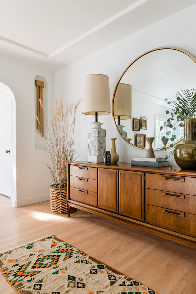 Photo of a beach style entry hall in Sacramento with white walls, light hardwood floors and beige floor.