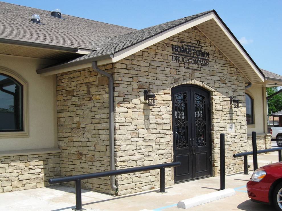 Example of a classic white one-story stone house exterior design with a shingle roof