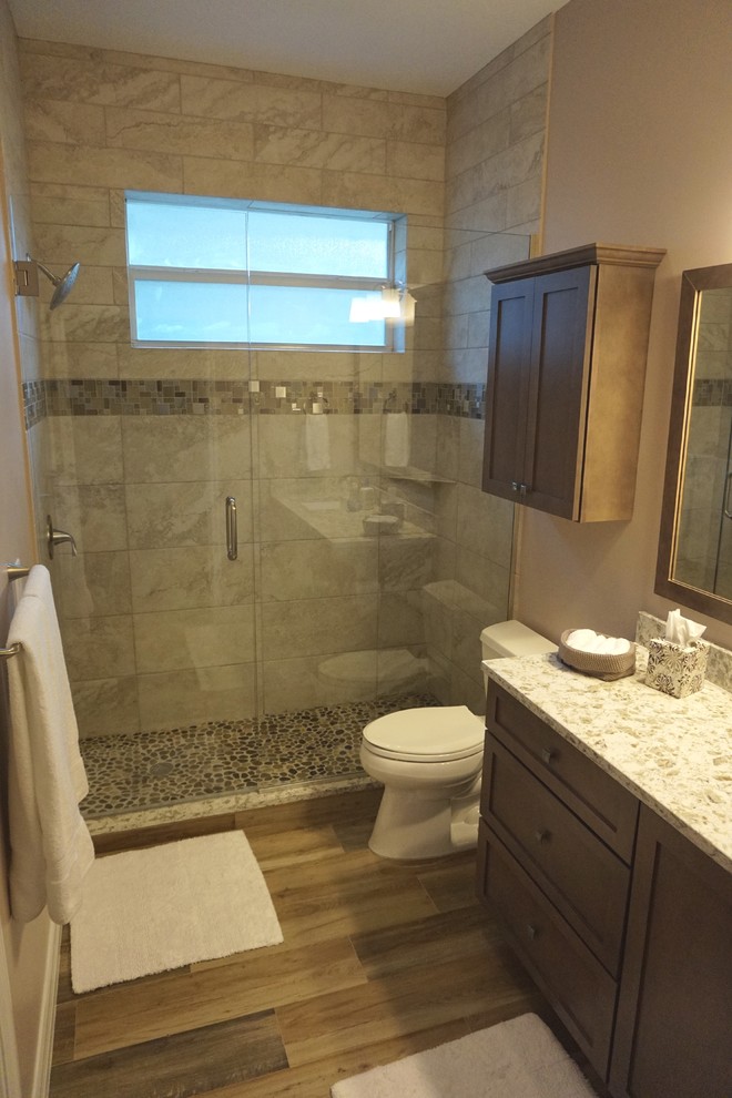 Photo of a mid-sized transitional master bathroom in Miami with shaker cabinets, dark wood cabinets, an alcove shower, a two-piece toilet, ceramic tile, beige walls, medium hardwood floors, an undermount sink, granite benchtops, brown floor and a hinged shower door.