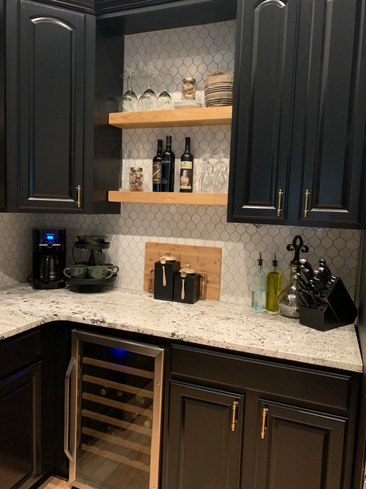 Exempel på ett mellanstort industriellt flerfärgad flerfärgat kök, med en undermonterad diskho, luckor med upphöjd panel, svarta skåp, granitbänkskiva, vitt stänkskydd, stänkskydd i mosaik, rostfria vitvaror och ljust trägolv