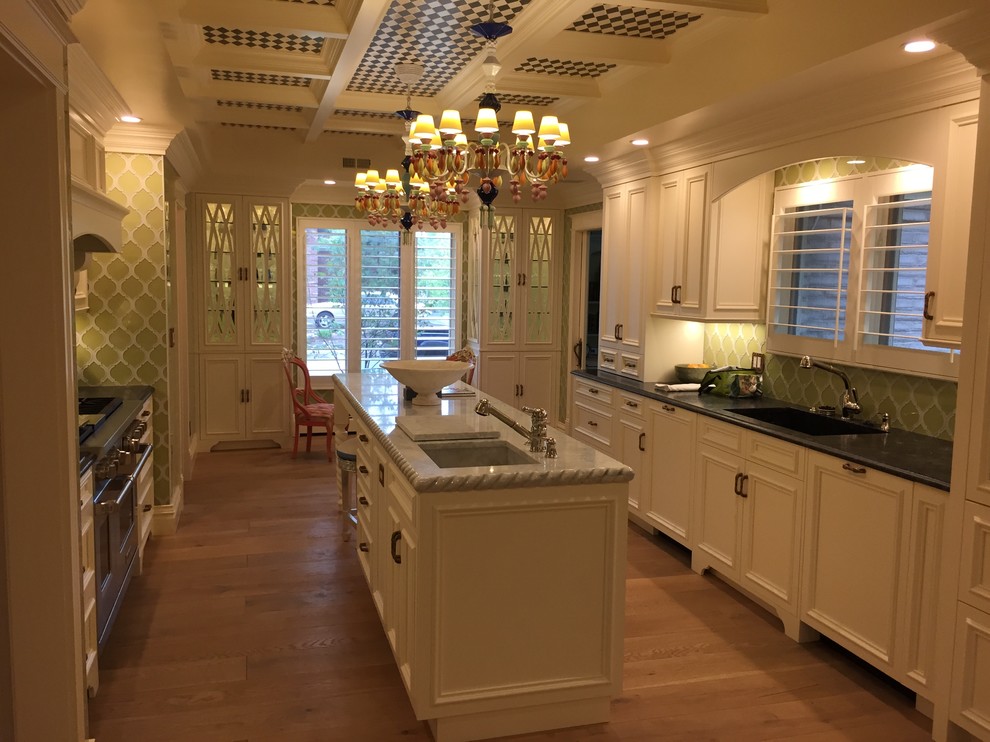 This is an example of a large country galley eat-in kitchen in Denver with an undermount sink, recessed-panel cabinets, white cabinets, marble benchtops, green splashback, ceramic splashback, panelled appliances, light hardwood floors and with island.