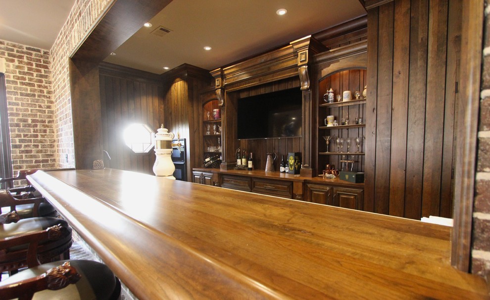 Example of a huge transitional walk-out medium tone wood floor basement design with brown walls, a two-sided fireplace and a stone fireplace