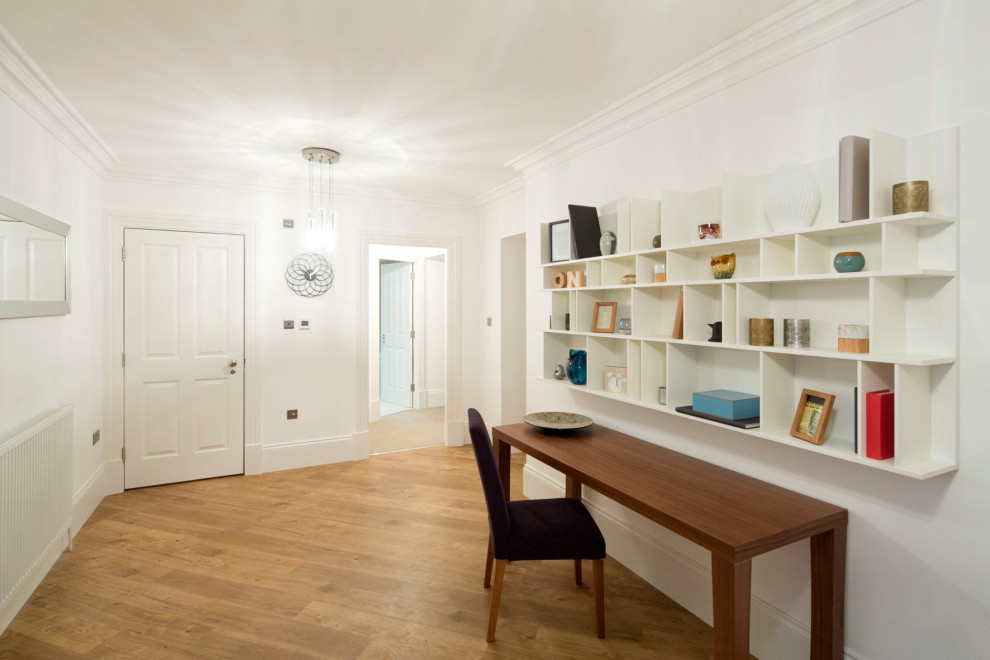 Photo of a large contemporary hallway in Glasgow with white walls, light hardwood floors and beige floor.