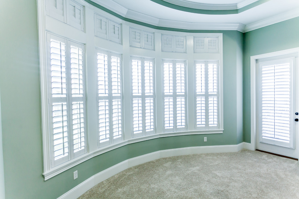 This is an example of a large mediterranean master bedroom in Jacksonville with green walls and carpet.