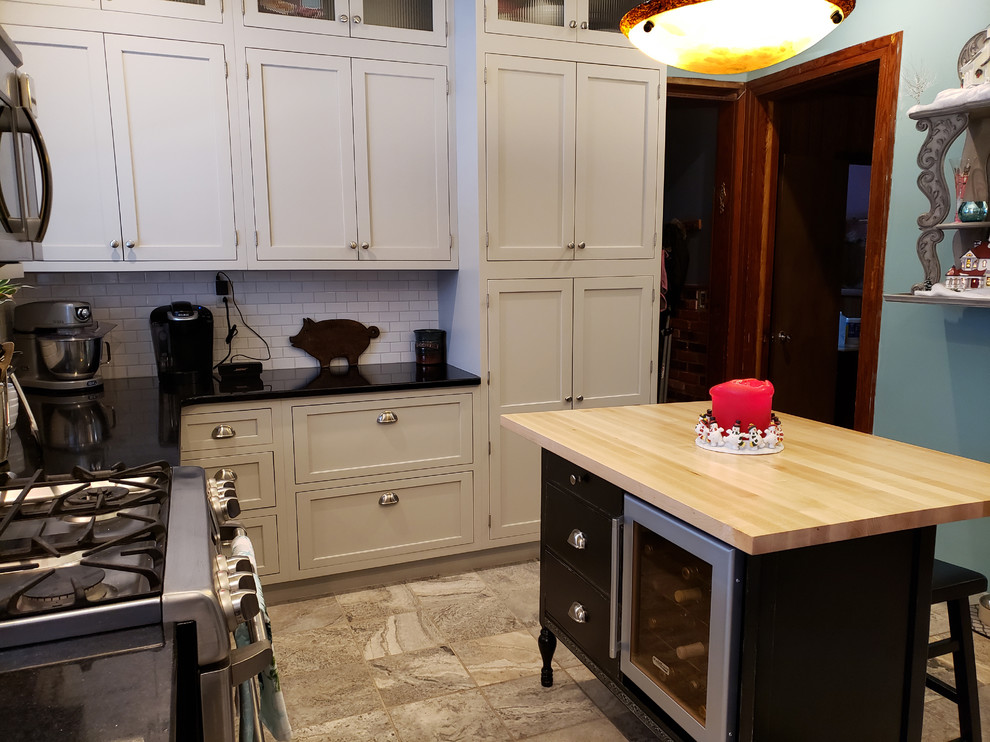Inspiration for a large transitional u-shaped ceramic tile and beige floor kitchen pantry remodel with a farmhouse sink, recessed-panel cabinets, gray cabinets, quartz countertops, white backsplash, subway tile backsplash, stainless steel appliances, an island and black countertops