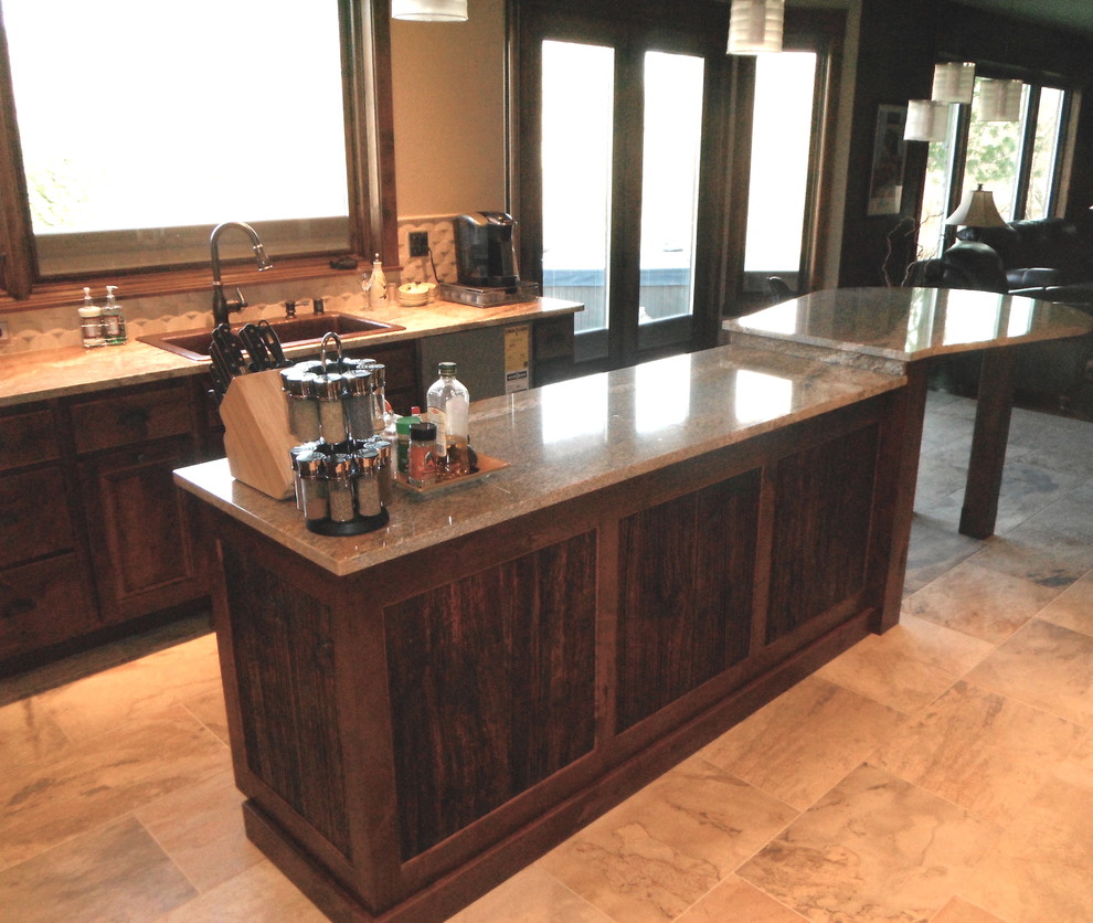 Kitchen - mid-sized craftsman u-shaped ceramic tile and beige floor kitchen idea with a double-bowl sink, flat-panel cabinets, dark wood cabinets, granite countertops, beige backsplash, stone tile backsplash, black appliances and an island