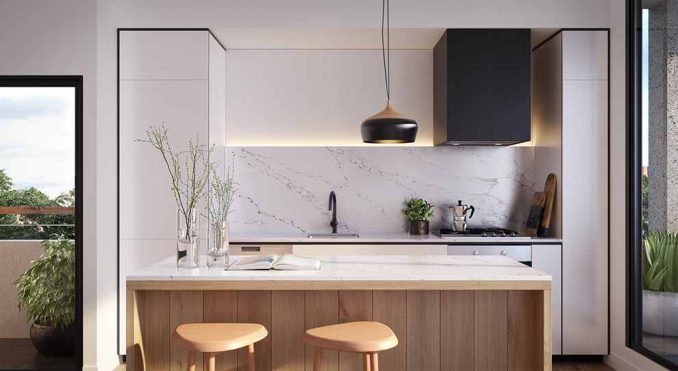 This is an example of a contemporary galley open plan kitchen in Melbourne with a drop-in sink, flat-panel cabinets, white cabinets, white splashback, marble splashback, black appliances and with island.