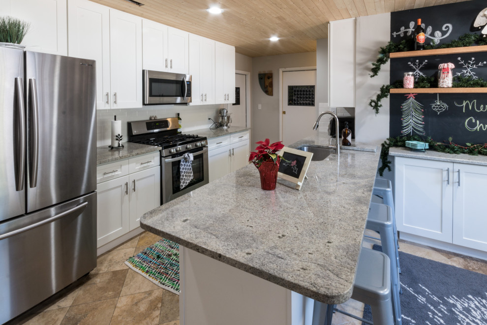 Example of a small transitional cement tile floor and brown floor eat-in kitchen design with an undermount sink, shaker cabinets, white cabinets, granite countertops, white backsplash, cement tile backsplash, stainless steel appliances, a peninsula and white countertops