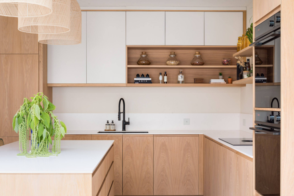 Design ideas for a mid-sized scandinavian kitchen in London with medium wood cabinets, with island and white benchtop.
