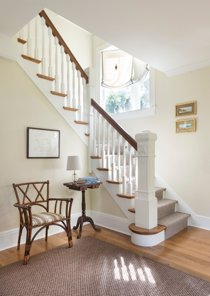 Photo of a beach style wood l-shaped staircase in Providence with painted wood risers.