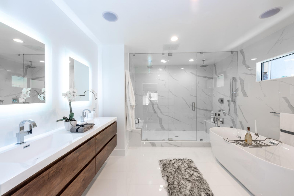 Photo of a large classic ensuite bathroom in Orange County with white cabinets, a built-in bath, an alcove shower, white tiles, white walls, porcelain flooring, a built-in sink, solid surface worktops, white floors, a hinged door, white worktops, double sinks, a floating vanity unit, exposed beams and a shower bench.