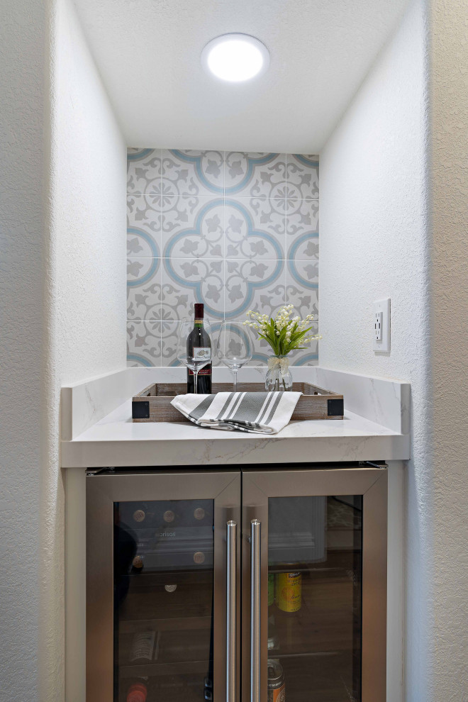 Mid-sized transitional l-shaped medium tone wood floor and brown floor eat-in kitchen photo in San Francisco with a single-bowl sink, recessed-panel cabinets, yellow cabinets, quartz countertops, white backsplash, ceramic backsplash, stainless steel appliances, an island and white countertops