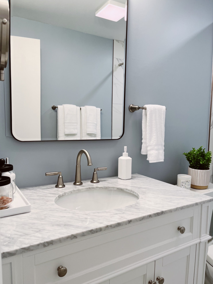Alcove shower - small transitional kids' white tile and porcelain tile porcelain tile, white floor and single-sink alcove shower idea with shaker cabinets, white cabinets, a two-piece toilet, blue walls, an undermount sink, marble countertops, gray countertops and a freestanding vanity